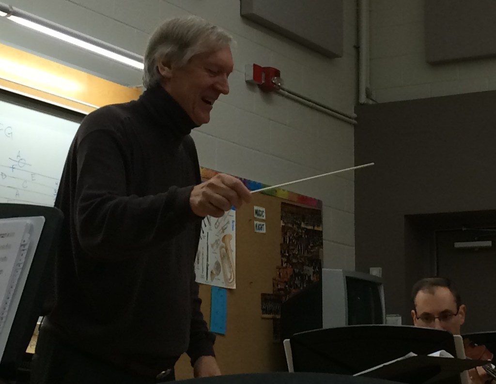 Conductor Matthew Poon smiling as he leads a rehearsal