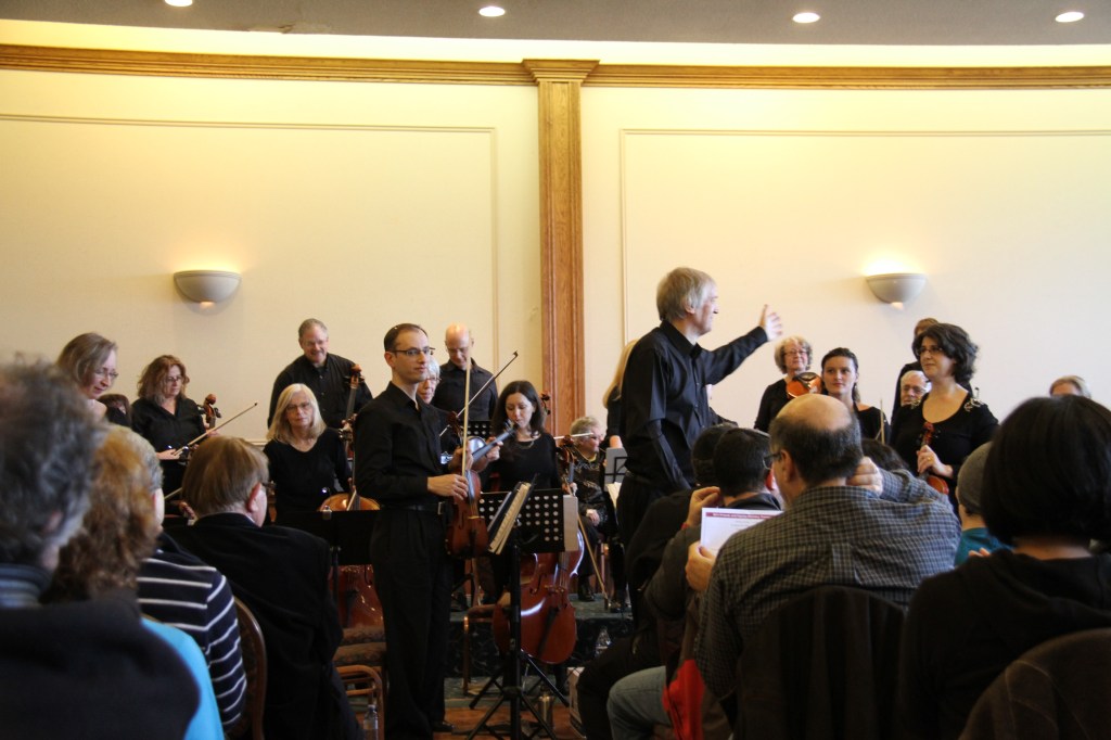 Conductor Matthew Poon leading Strings Attached Orchestra at the 2014 Friends and Family Holiday Concert, seen from the audience