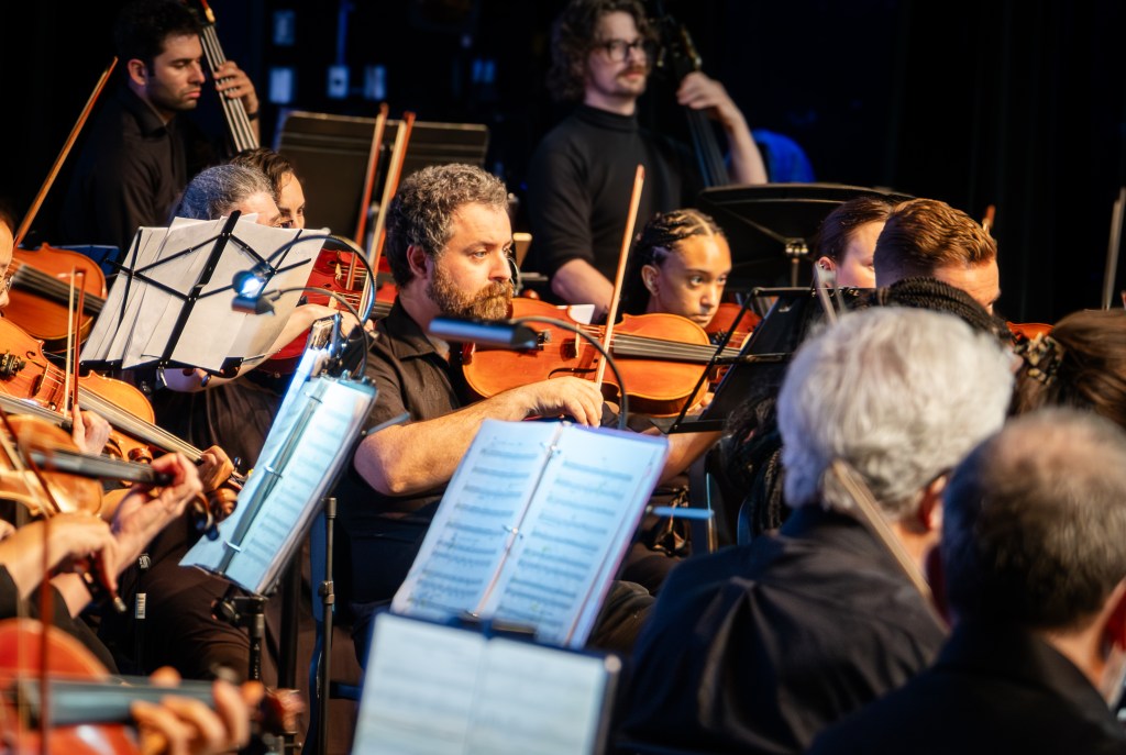 String players performing under warm stage light