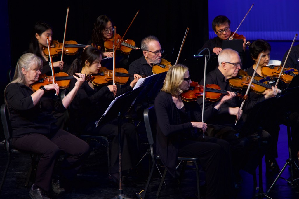 Violinists playing together on stage