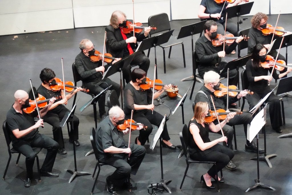 Violinists rehearsing on stage before the concert