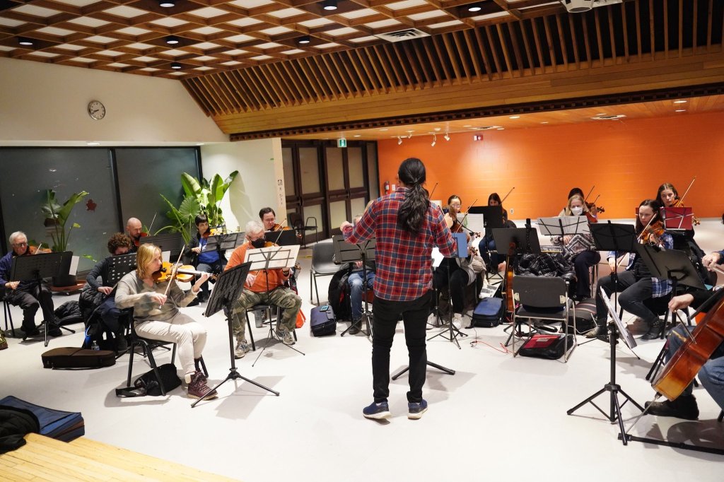 The conductor walking among the players during rehearsal