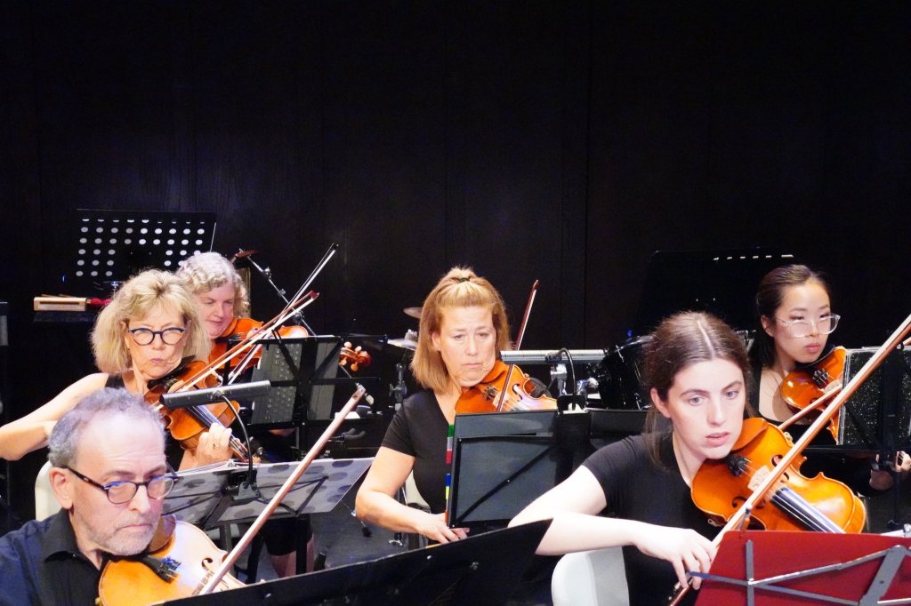 Violinists playing on stage at the Al Green Theatre