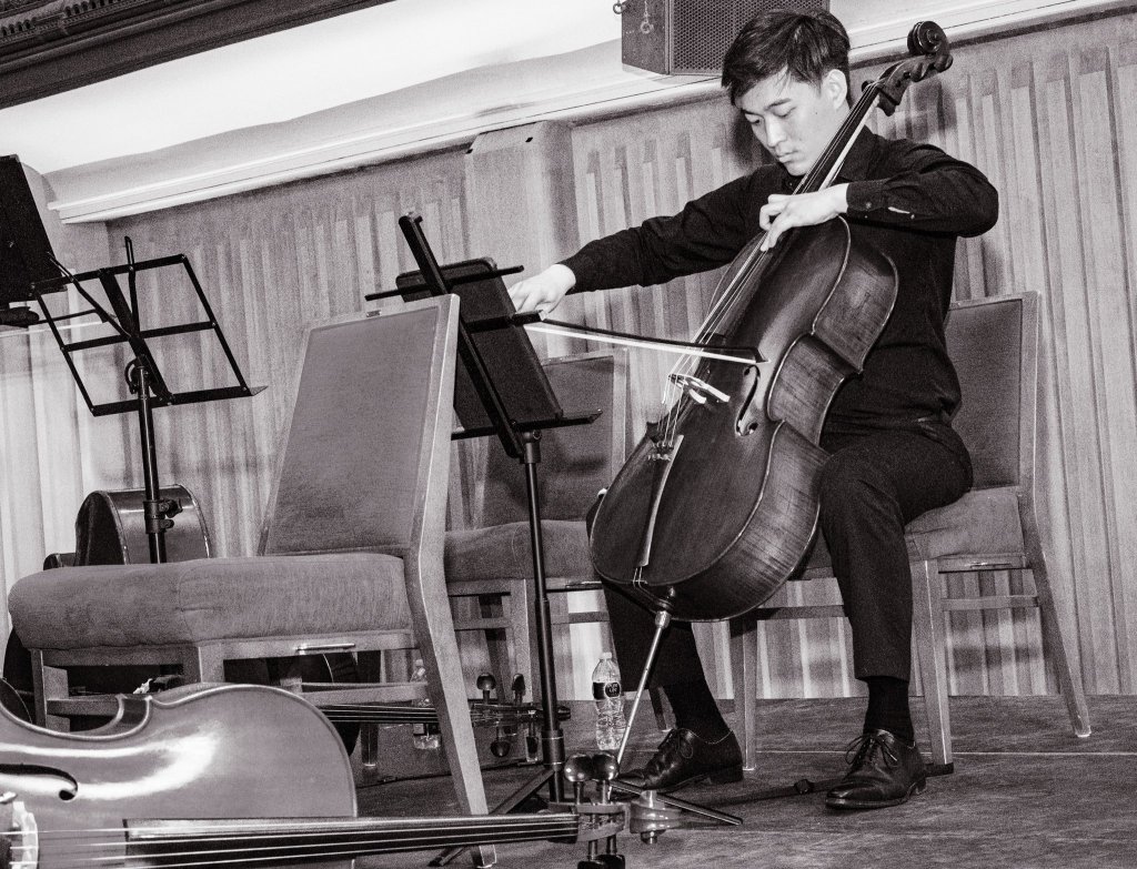 Black-and-white portrait of a cellist on stage