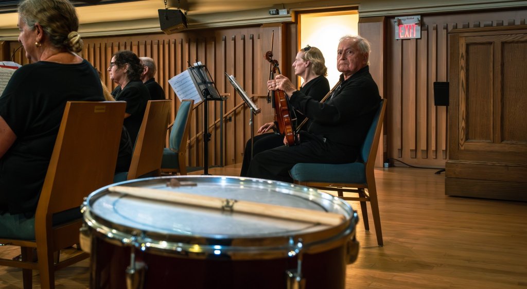 A percussionist at the timpani beside the orchestra