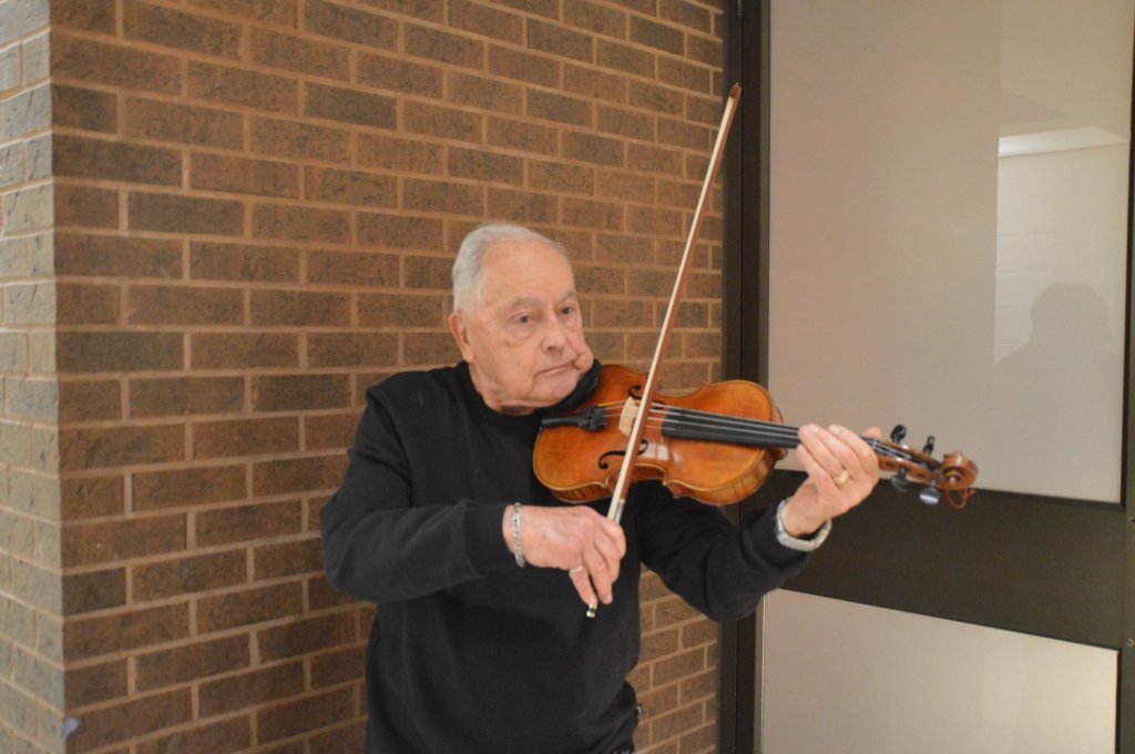 Portrait of a violinist from the orchestra, playing beside the rehearsal hall door