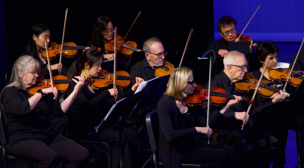 Violinists playing together on stage