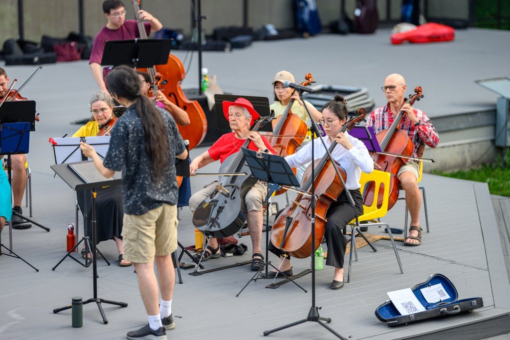 The conductor leading the players at Earl Bales Park