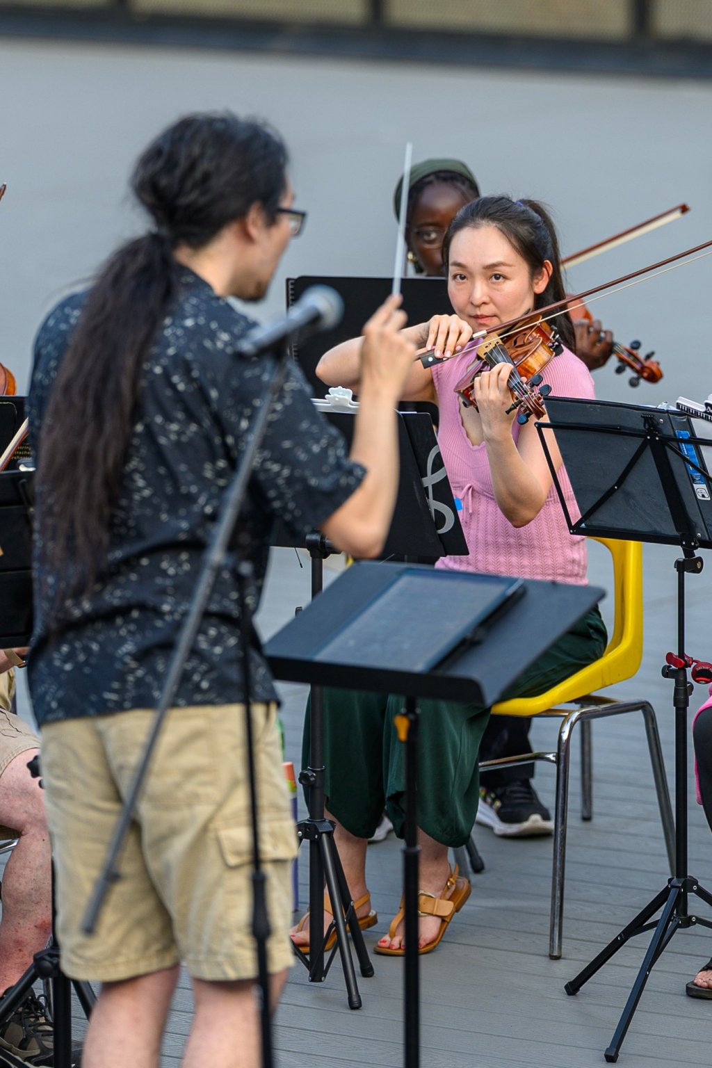 A young violinist playing alongside an adult musician at Earl Bales Park